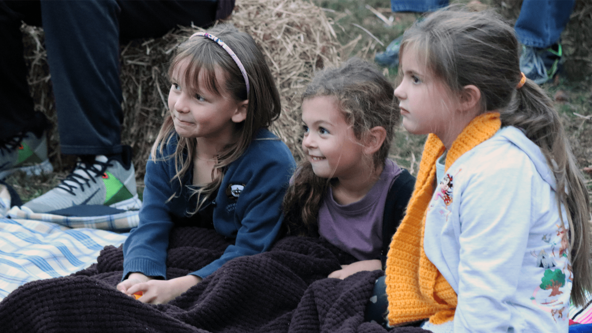 Kindergarten students watching an outside movie in the fall
