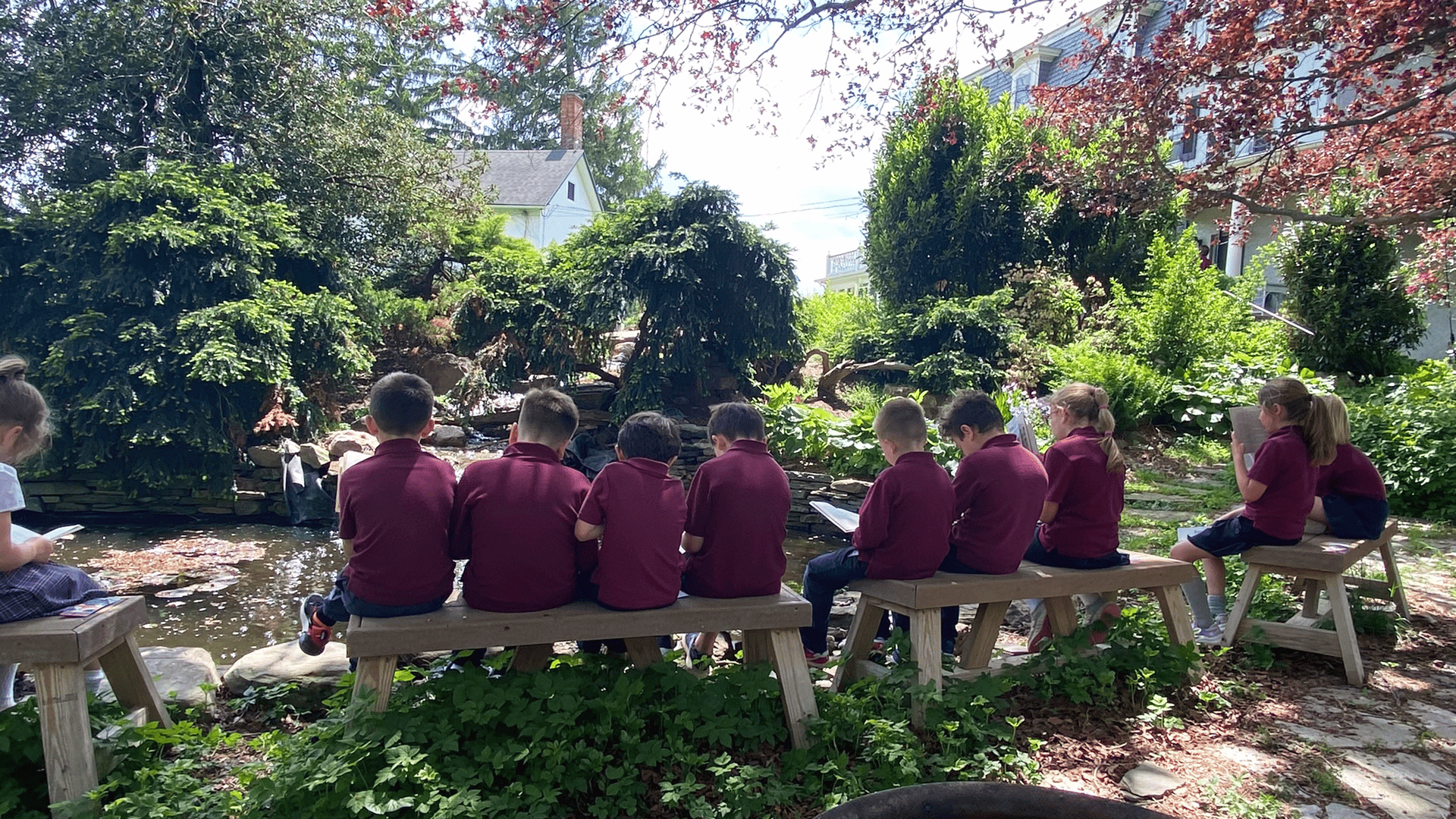 Young students reading by the campus pond