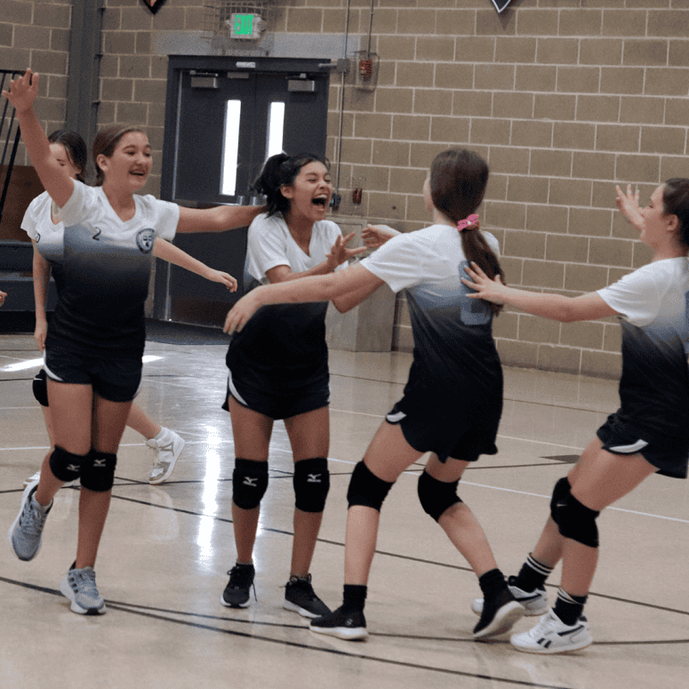 Girl's volleyball team hugging after a win