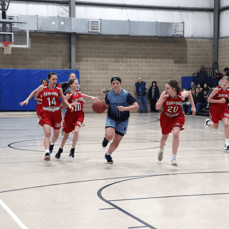 Girls basketball - Varsity player dribbling around opposing team
