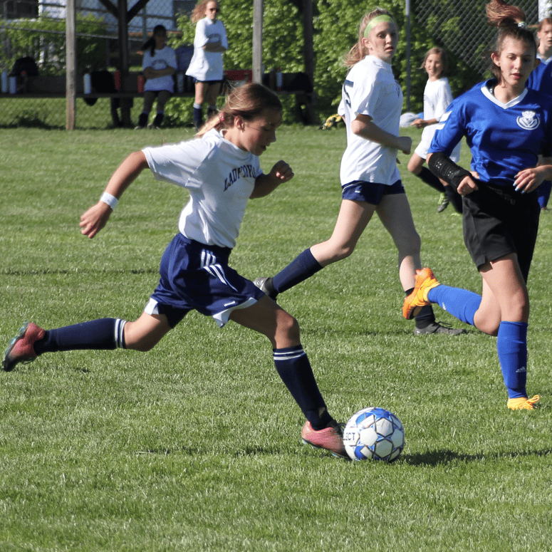 Girl's Varsity soccer - Redeemer female breaking away from opponent