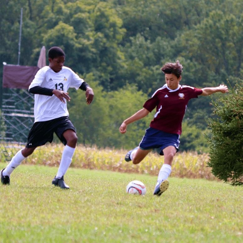 High school boys soccer - student with a large kick